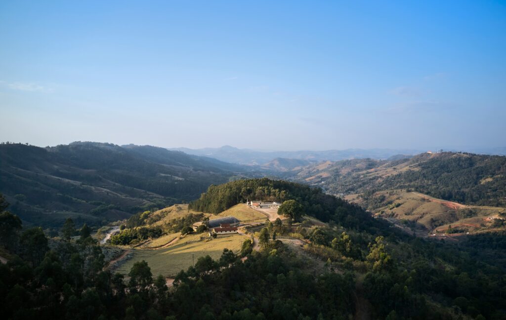 Vista panorâmica de montanhas e vegetação do Pico do Fonseca em Serra Negra, interior de São Paulo, com um céu azul limpo ao fundo.
