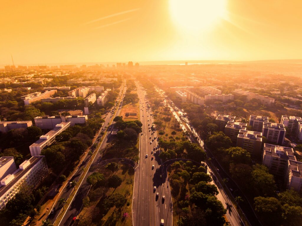 Vista aérea Brasília Eixo Monumental prédios luz dourada pôr do sol trânsito avenida principal cidade planejada